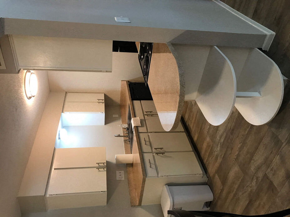 an overhead view of a kitchen with white cabinets and a table