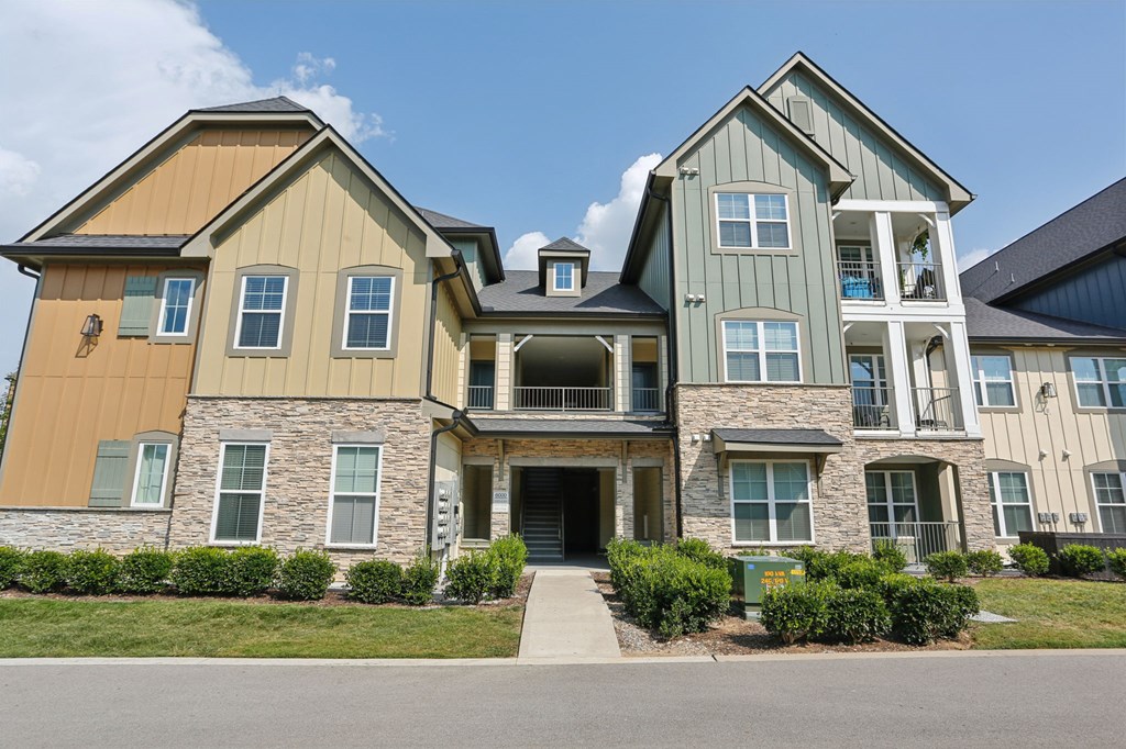A large two-story house with a mix of stone and siding exterior.