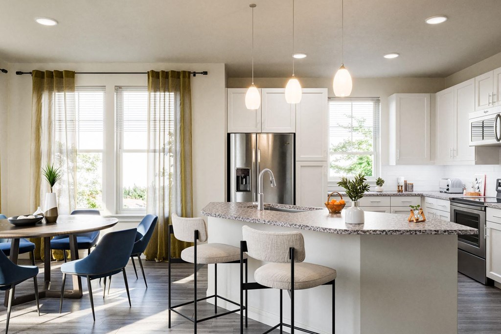 a kitchen with a large island and a table with chairs