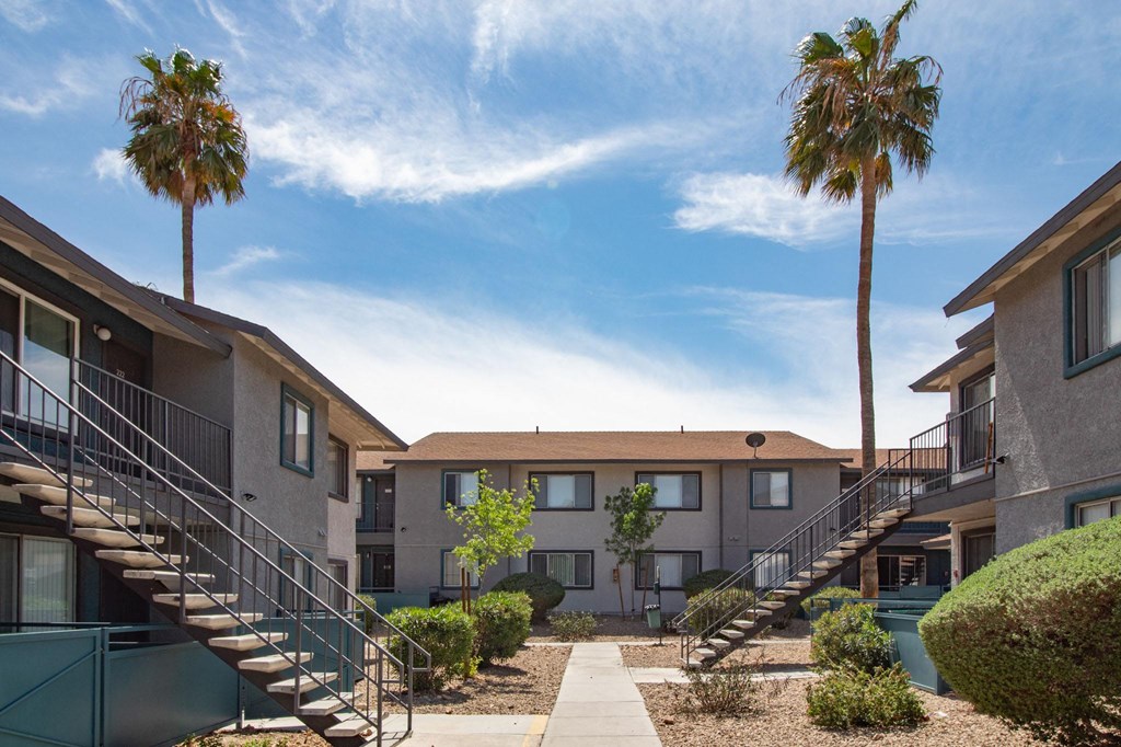 a row of apartments with stairs and palm trees
