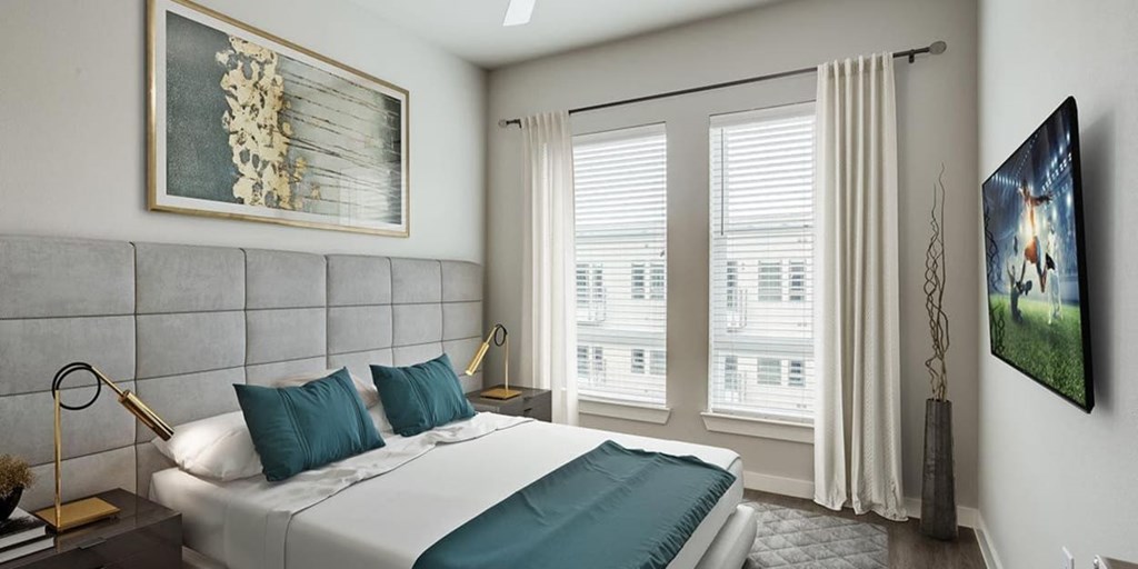 A bedroom with a large bed and a painting on the wall.