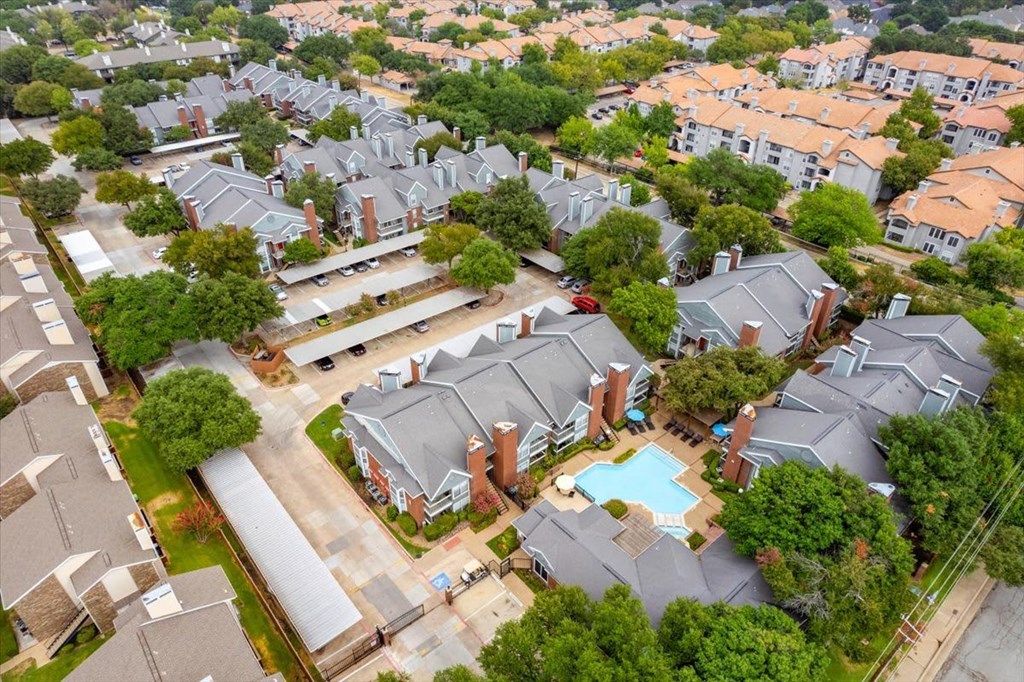 A bird's eye view of a residential area with houses and a swimming pool.