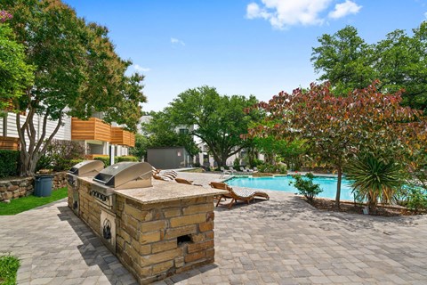 a backyard with a pool and a barbecue grill