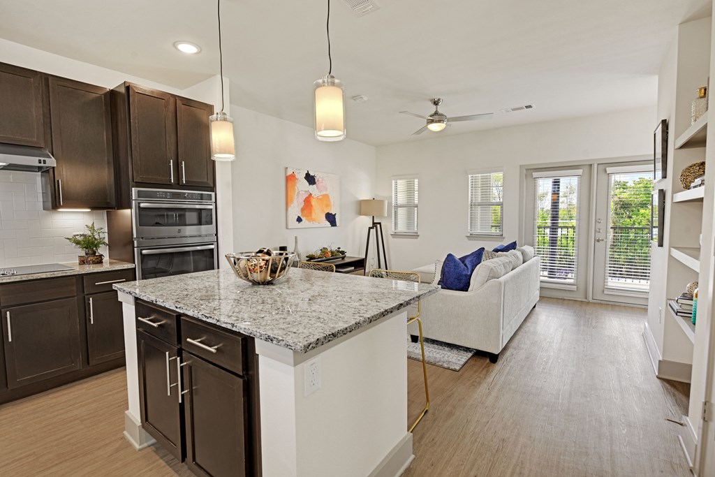an open kitchen and living room with a granite counter top