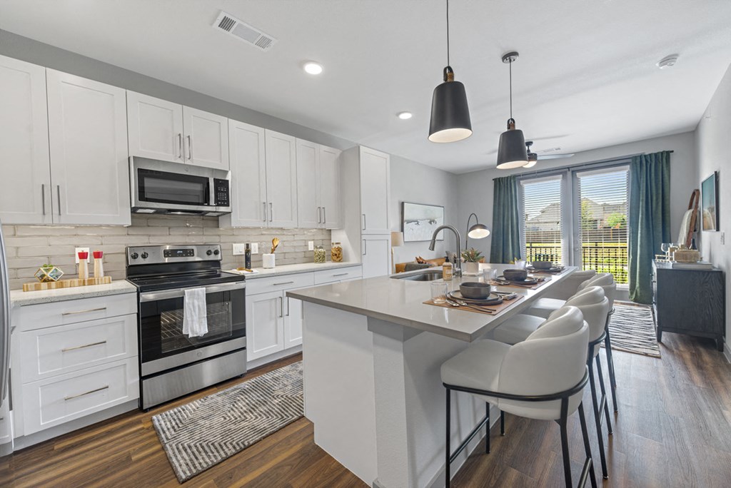 a kitchen with a large island and a table with chairs