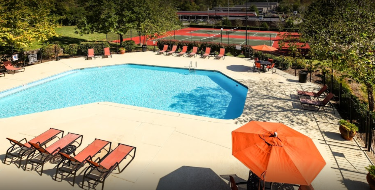 a resort style pool with lounge chairs and umbrellas