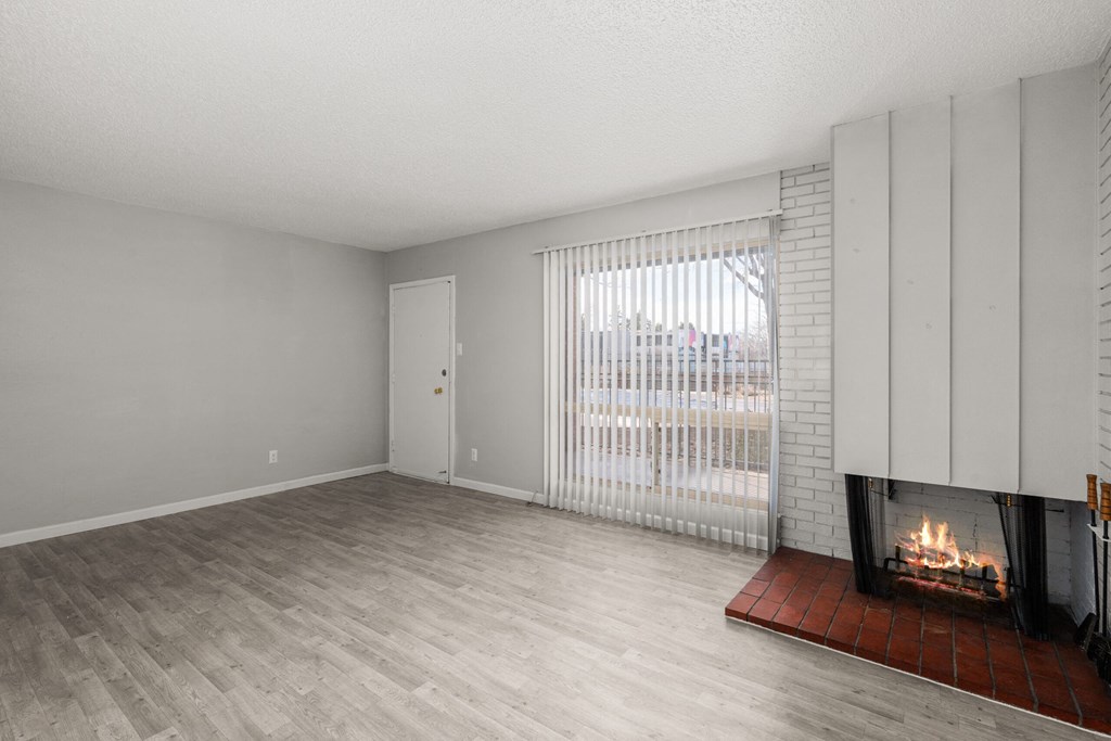 an empty living room with a fireplace and a window