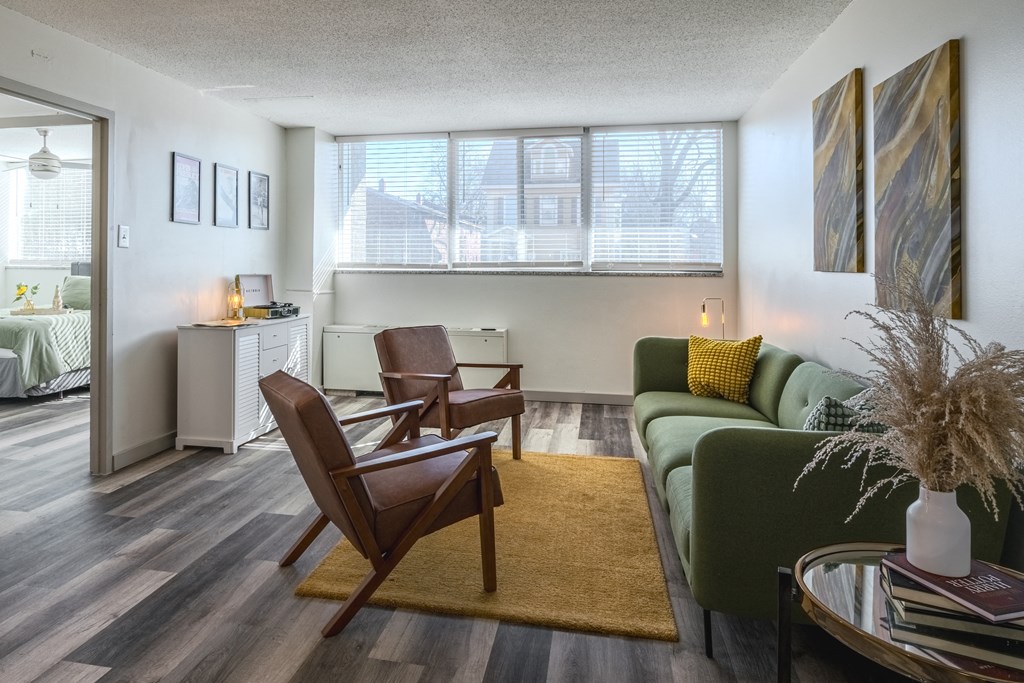 a living room with a green couch and two chairs and a table