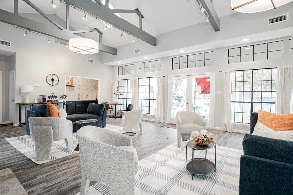 a living room with white walls and white furniture and windows