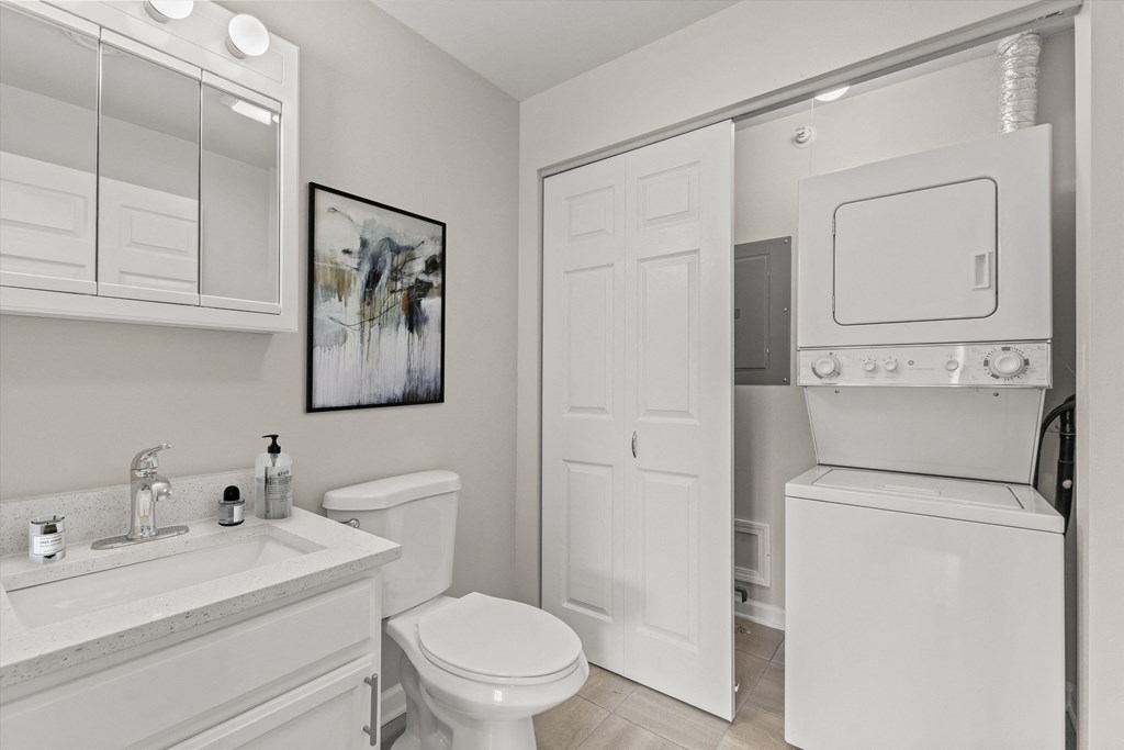 a white bathroom with a white toilet and sink and a white closet