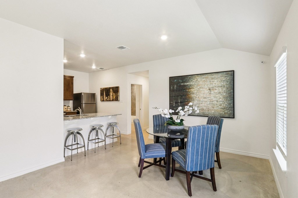 A dining room with a table set for four.