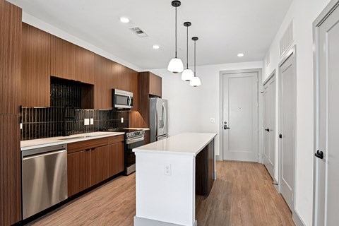 A modern kitchen with wooden cabinets and a white island.