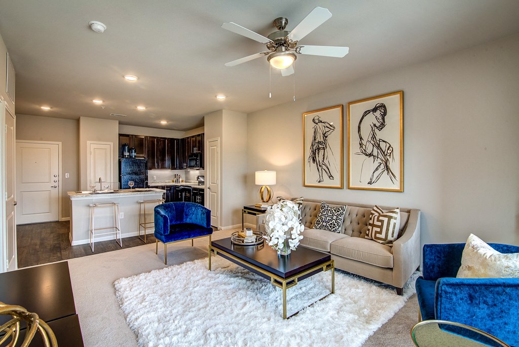 a living room with a ceiling fan and a white rug