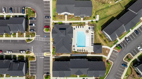 an overhead view of a parking lot with a swimming pool