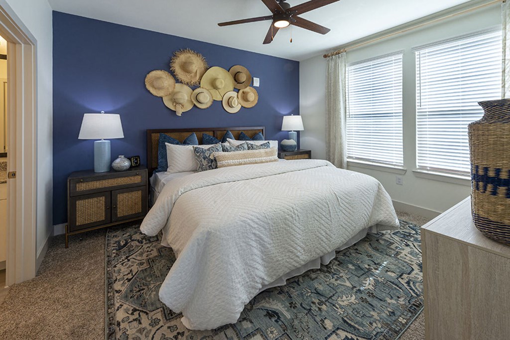 a blue accent wall in a bedroom with a white bed