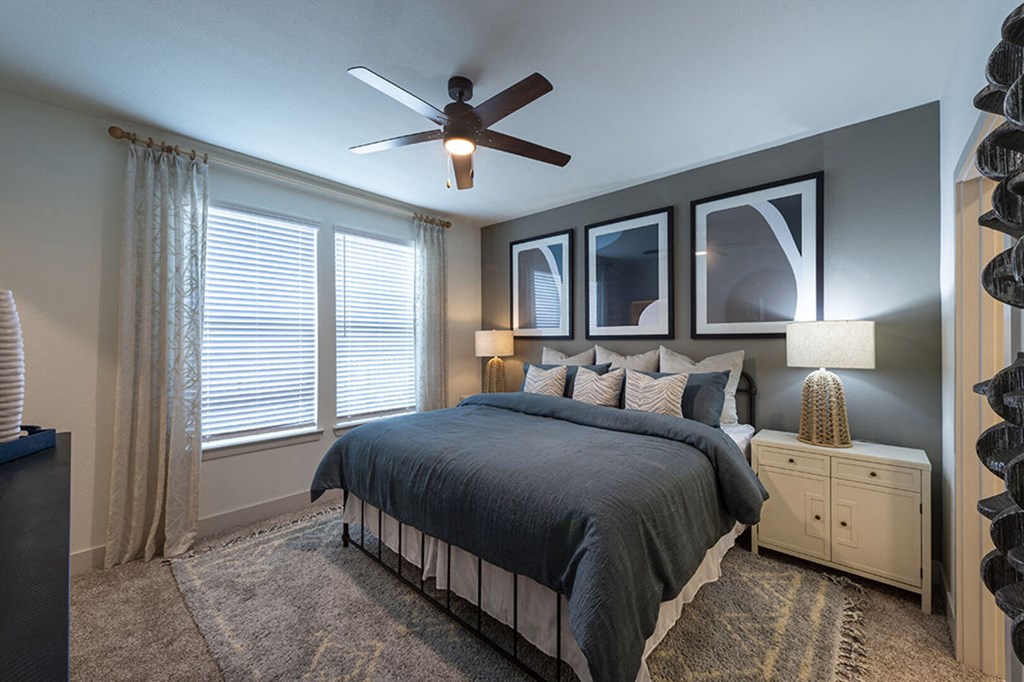 a bedroom with a bed and a ceiling fan