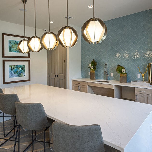 a kitchen with a white counter top and chairs