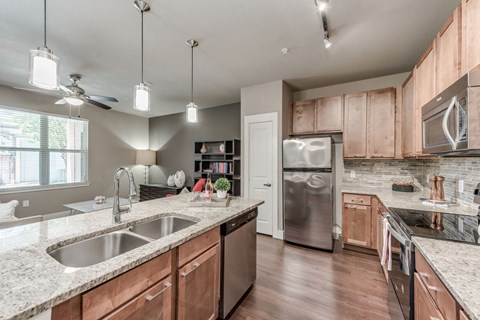 A kitchen with a sink, refrigerator, and a window.