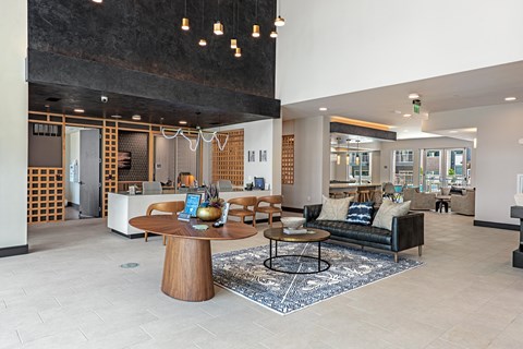 A modern living room with a wooden coffee table and a black couch.