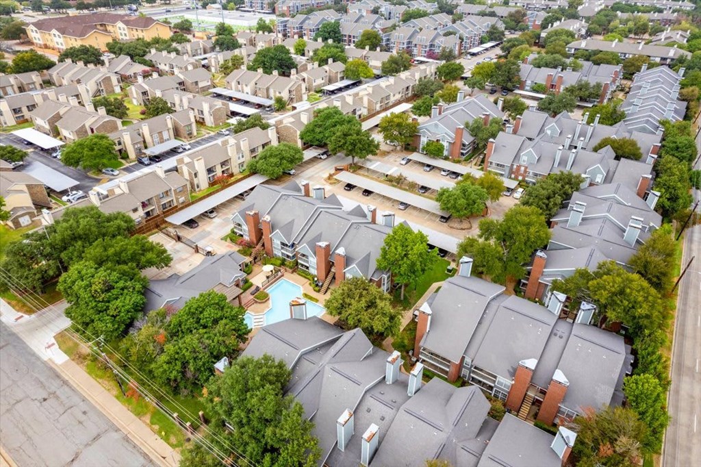 A bird's eye view of a residential area with houses and a swimming pool.