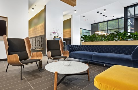 a lobby with blue couches and chairs and a table