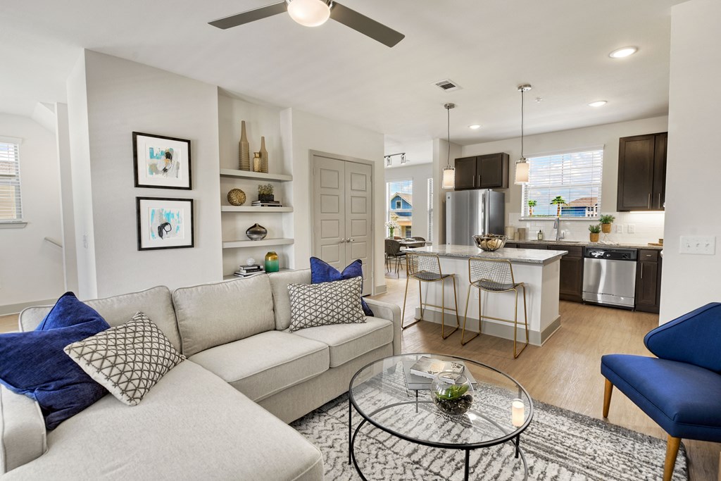 a living room and kitchen with a couch and a glass table