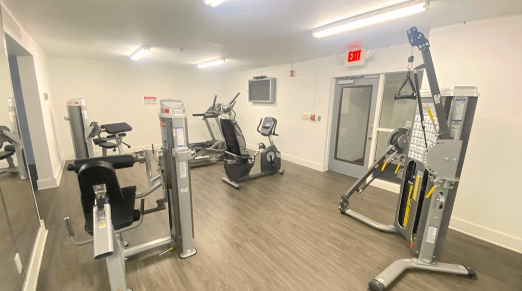 a gym with cardio equipment and weights in a building