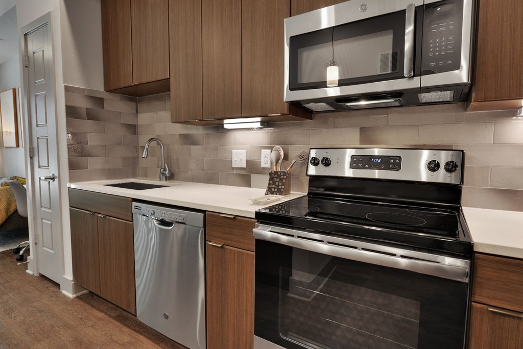 a kitchen with wooden cabinets and stainless steel appliances