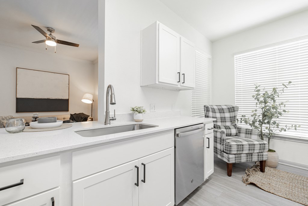 a white kitchen with a sink and a window