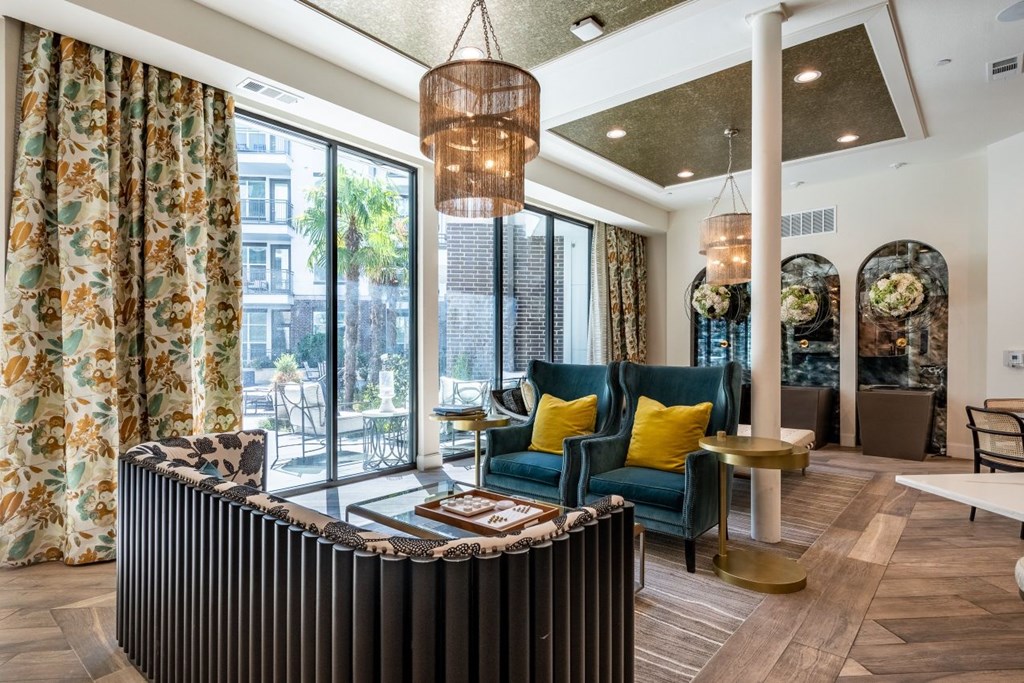 A living room with a large window and a view of the city.