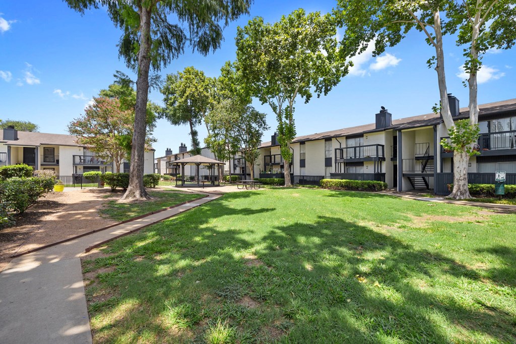 exterior view of apartments with grass and trees at thevillage at metro ridge