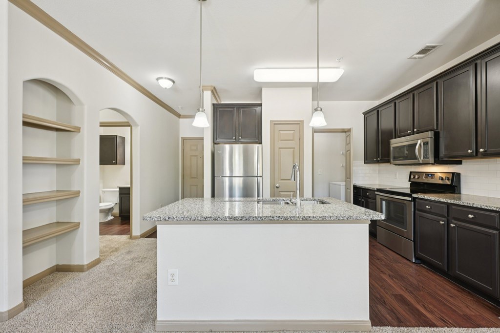 A kitchen with a granite countertop and black cabinets.
