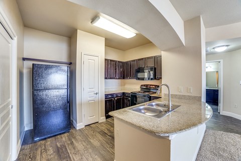 A kitchen with a sink and a refrigerator.