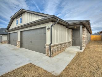 a home with two garage doors and a concrete driveway