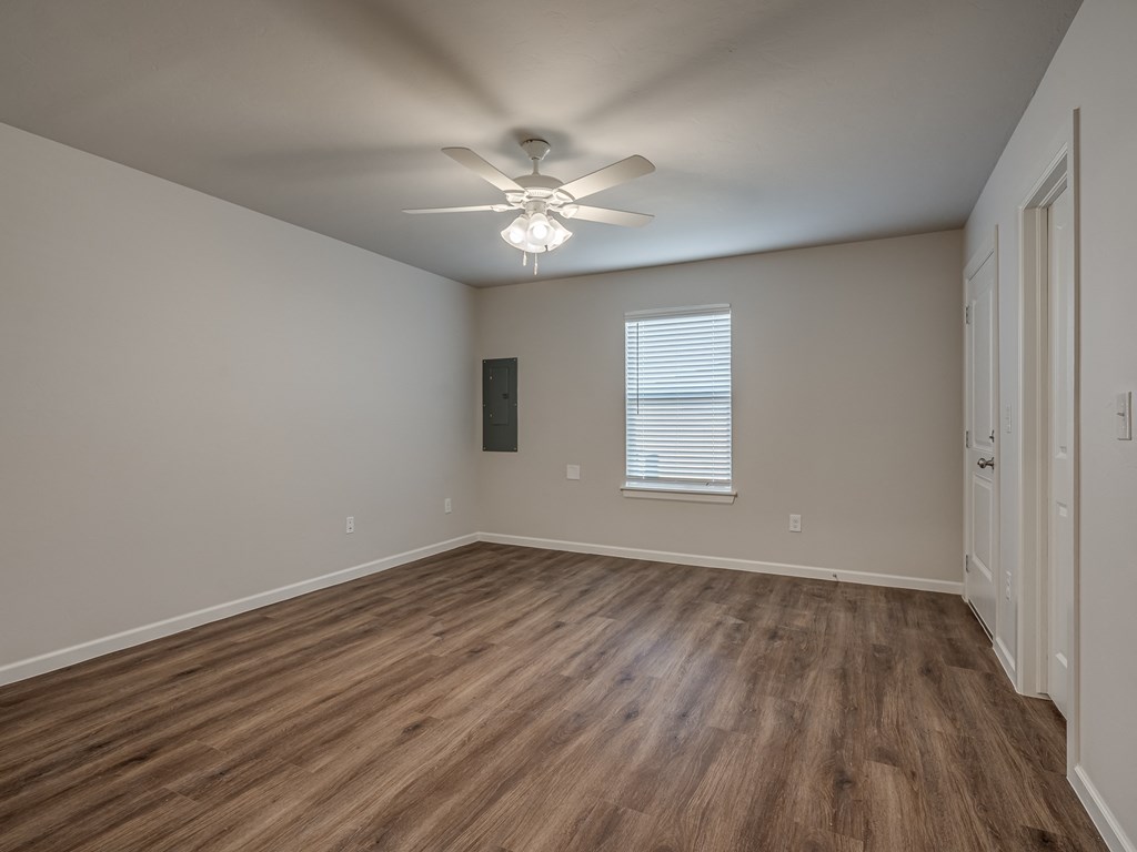 a bedroom with hardwood floors and a ceiling fan