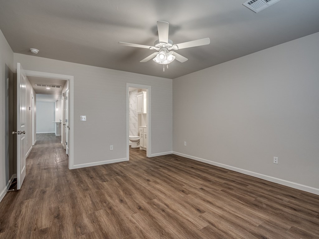 a bedroom with hardwood floors and a ceiling fan