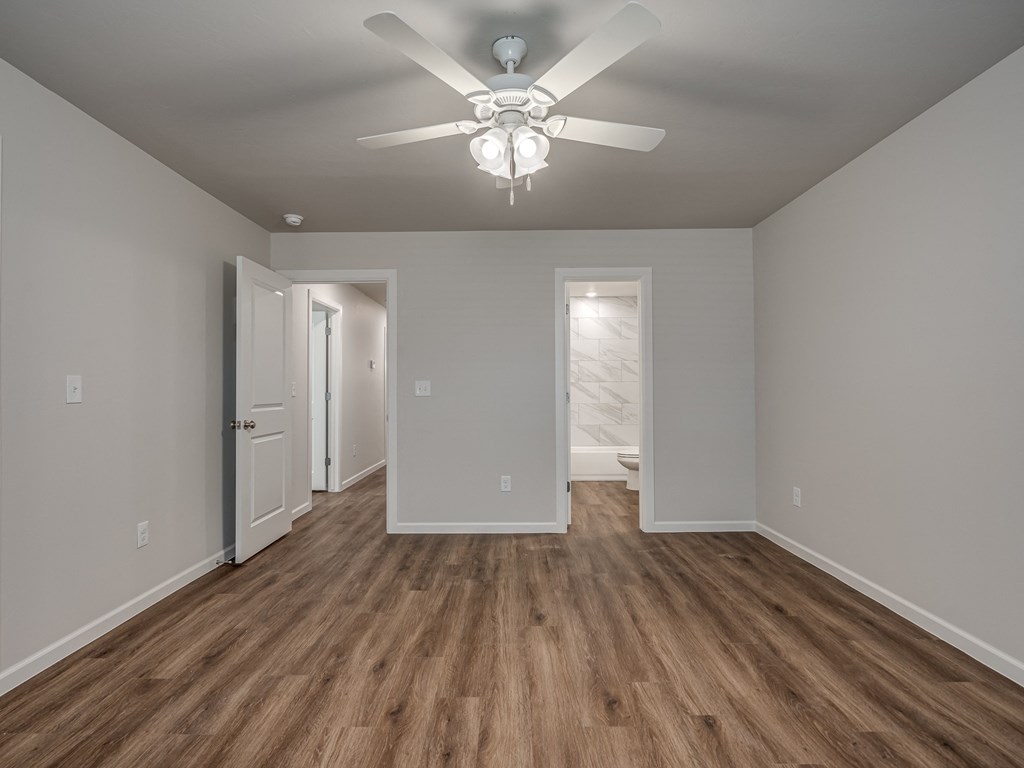 a bedroom with a ceiling fan and hardwood floors