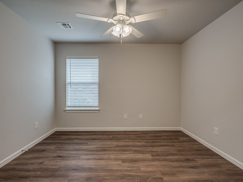 a bedroom with hardwood floors and a ceiling fan
