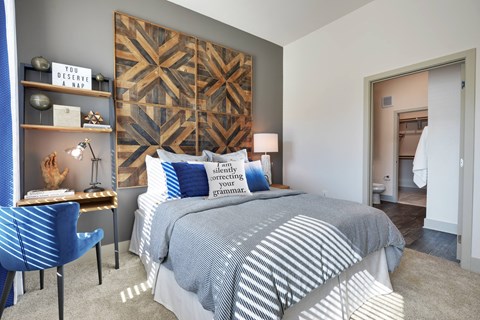 A bedroom with a large bed and a blue chair.