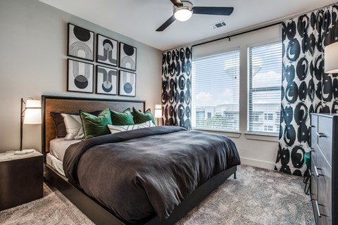 A bedroom with a large bed and a ceiling fan.