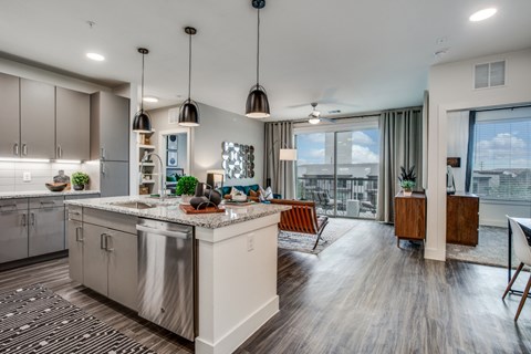 A modern kitchen with a large island and a view of the city.