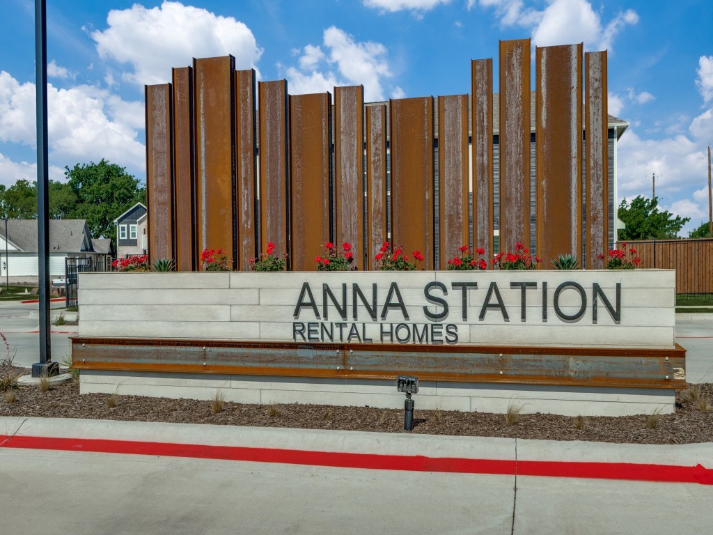 A sign for Anna Station Rental Homes is displayed in front of a building.