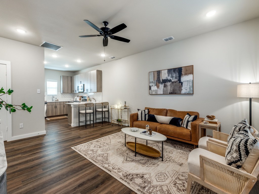 A living room with a brown couch and a rug.