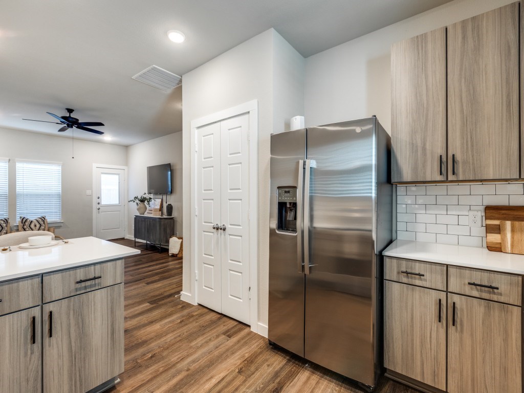A modern kitchen with a stainless steel refrigerator and wooden cabinets.