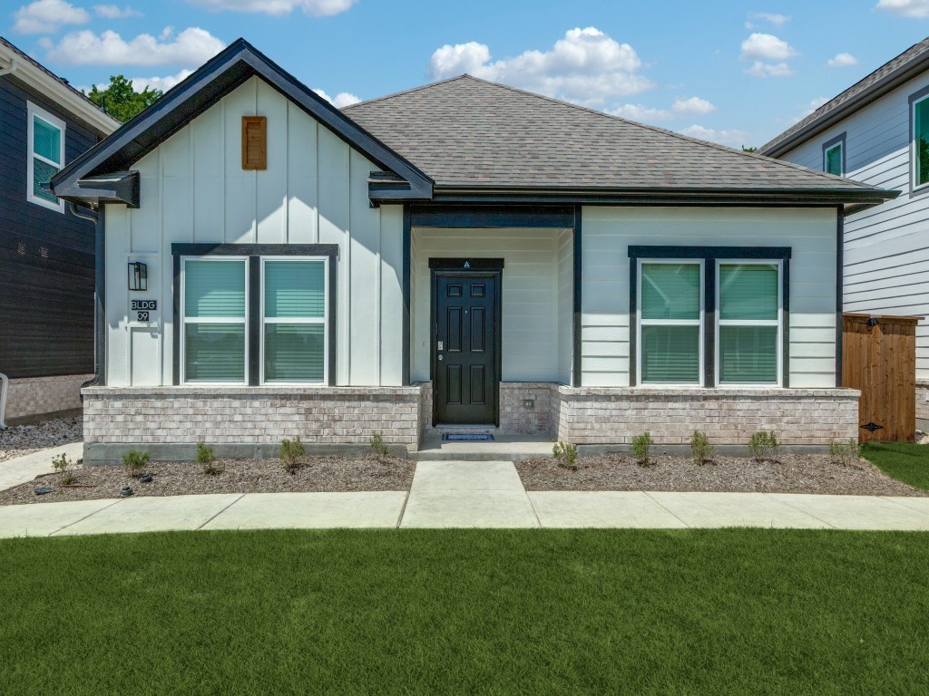 A modern house with a black front door and a grey roof.