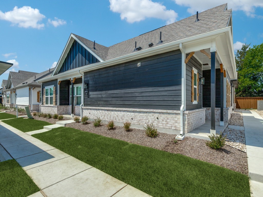 A modern house with a grey front yard.