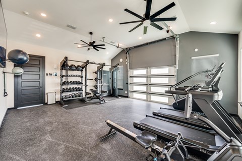 A spacious home gym with a treadmill, weights, and exercise equipment.
