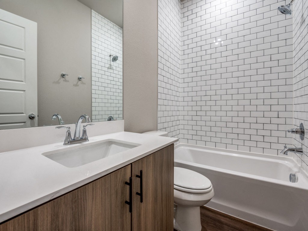 A white bathroom with a white tub and a white sink.