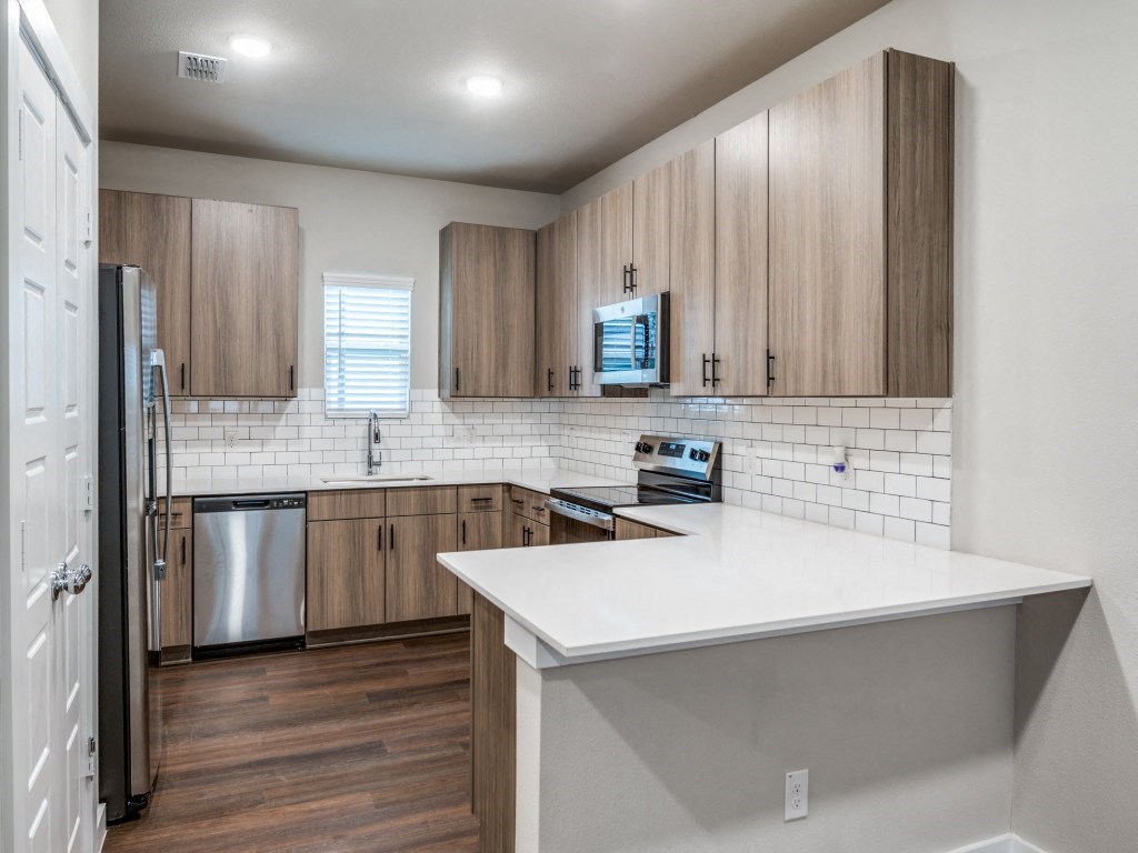 A kitchen with wooden cabinets and a white countertop.
