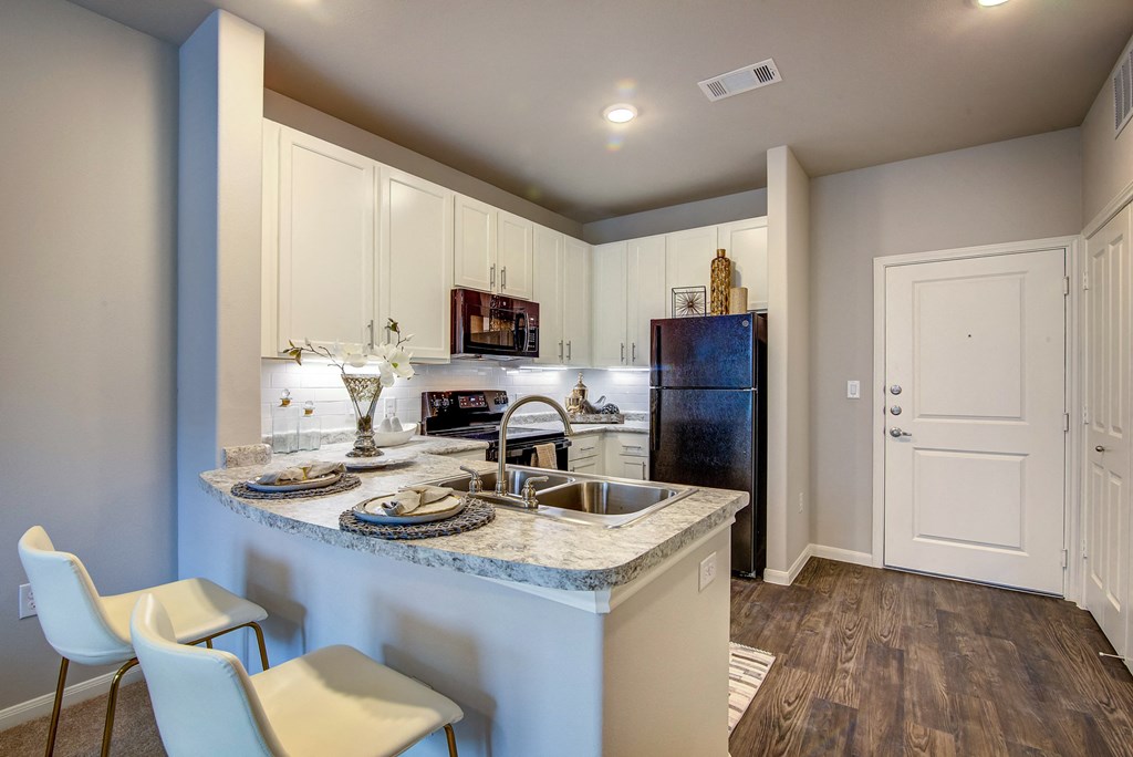 a kitchen with white cabinets and blue granite countertops